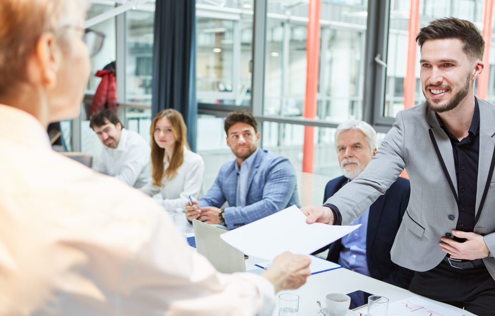 men and women by a conference table